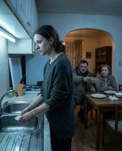 Szinte soha nem csináltam ilyet, de hetek óta nyugtalanító érzésem volt – egy elsöprő érzés, hogy valami nincs rendben. Nem tudtam logikusan megmagyarázni. Egyszerűen anyai ösztön volt, és ezúttal úgy döntöttem, nem hagyom figyelmen kívül. Megnyomtam a csengőt. Senki sem válaszolt. Egy pillanatnyi várakozás után elővettem a pótkulcsot, amit Laura évekkel ezelőtt adott nekem, „csak a biztonság kedvéért”. Abban a pillanatban, hogy beléptem, megfáztam. Nem a téli hideget, hanem egy mélyebb hideget – egy hideget, amitől a ház kellemetlennek és fülledtnek tűnt. A konyhából állandóan a folyó víz hangja hallatszott. Halkan közeledtem. Amit láttam, megállásra késztetett. Laura a mosogatónál állt, és újra meg újra mosogatott. Vékony pulóvert viselt, ami egyértelműen túl meleg volt. A keze enyhén remegett, a válla merev. A haja közönyösen hátra volt kötve, és az arca kimerültnek tűnt – sem könnyek, sem harag, csak fáradtság. A férje, Daniel, és az édesanyja, Margaret, az étkezőasztalnál ültek. Meleg takarókba burkolózva kényelmesen ettek és beszélgettek, mintha mi sem történt volna. Laura szinte láthatatlan volt. Margarita eltolta az üres tányérját. Daniel azonnal felállt, és bekiáltott a konyhába: „Kész vagy már? Hozz még ennivalót!” Laura didergett. Elzárta a vizet, a nadrágjába törölte a kezét, és halkan válaszolt: „Igen.” Abban a pillanatban megértettem. Ez nem hétköznapi fáradtság volt. Ez nyomás volt. Kontroll. Az a csendes fajta, ami napról napra kifáraszt. Margarita végre észrevett. Udvariasan elmosolyodott, de hiányzott belőle a melegség. „Ó, ma nem számítottunk rád” – mondta mozdulatlanul.