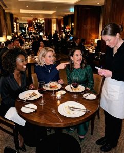 A kegyetlen szavak mélyebb sebet ejtenek, mint a pengék, de néha a megfelelő ember pontosan tudja, hogyan állítsa el a vérzést. Amikor három gazdag nő gúnyolt egy pincérnőt, mert „szegény szagú”, az egész terem megdermedt. Senki sem szólt, senki sem avatkozott közbe – egészen addig, amíg a barátom fel nem állt, és mindent megváltoztatott.